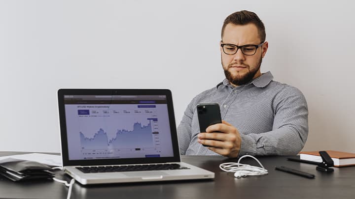 A laptop and a man with a phone